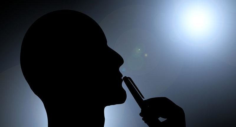 silhouette of man's head with pen touching his lips