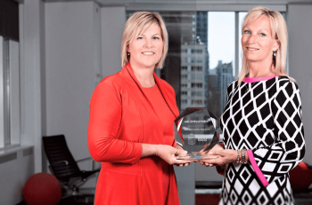 ABL's 2 founders holding a glass award trophy