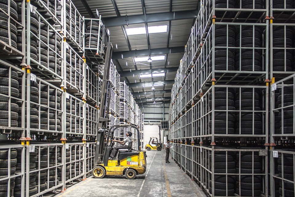 internal view of a tire warehouse and forklift removing a pallet of tires