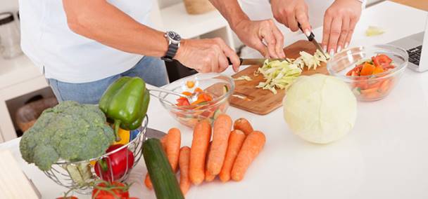 close-up of hands preparing fruit and vegetables for cooking