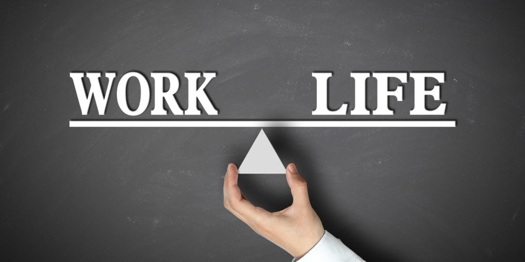 black board with words "work" and "life" on a balancing line.