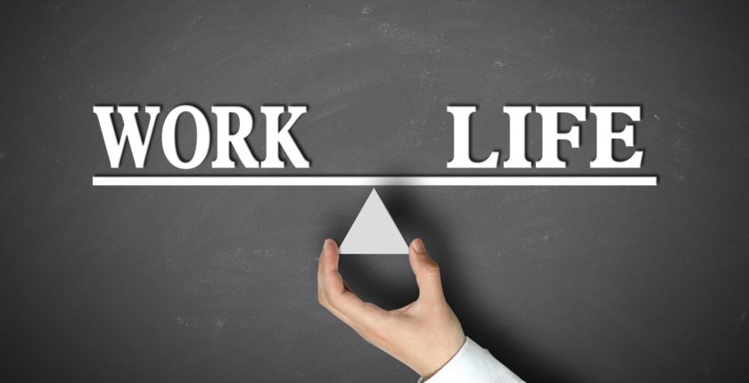 black board with words "work" and "life" on a balancing line.