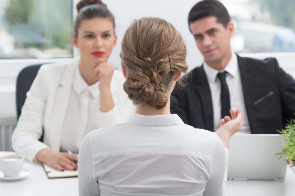 3 people speaking across a table as if in an interview