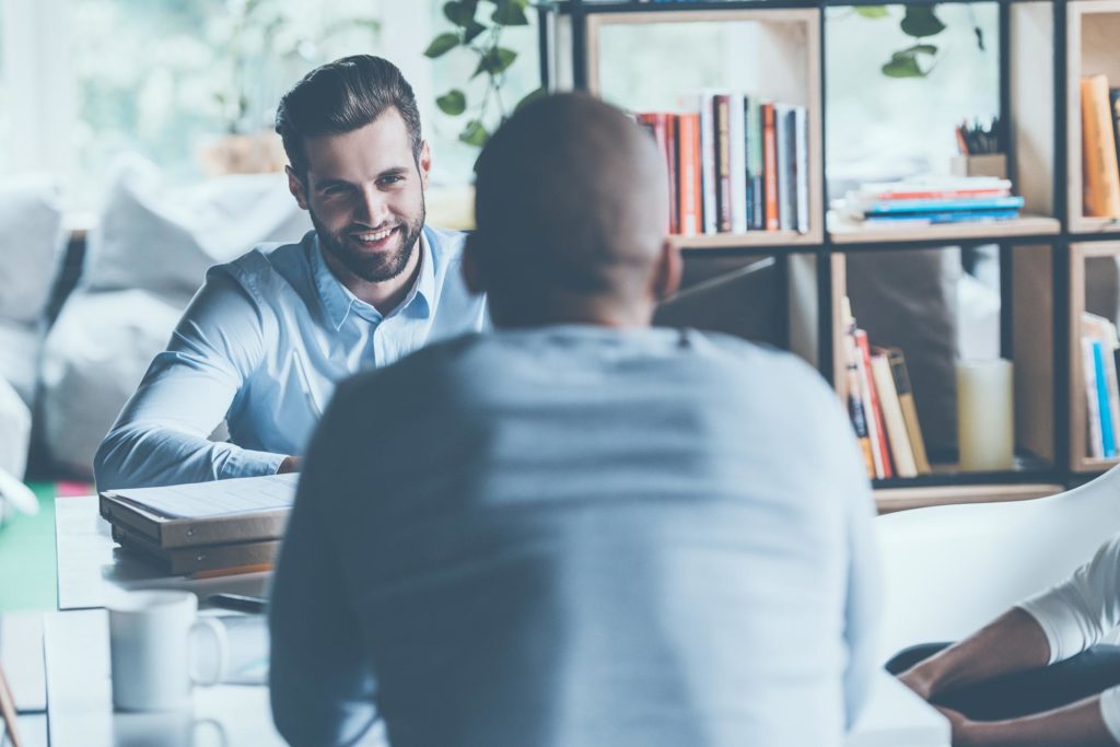 two men chatting across a table