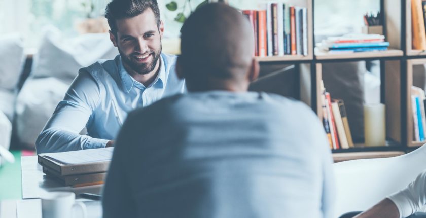 two men chatting across a table