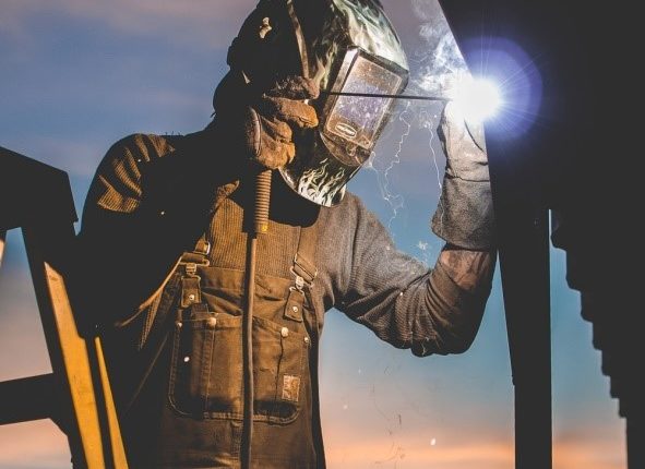 Worker welding wearing Welding helmet and overalls