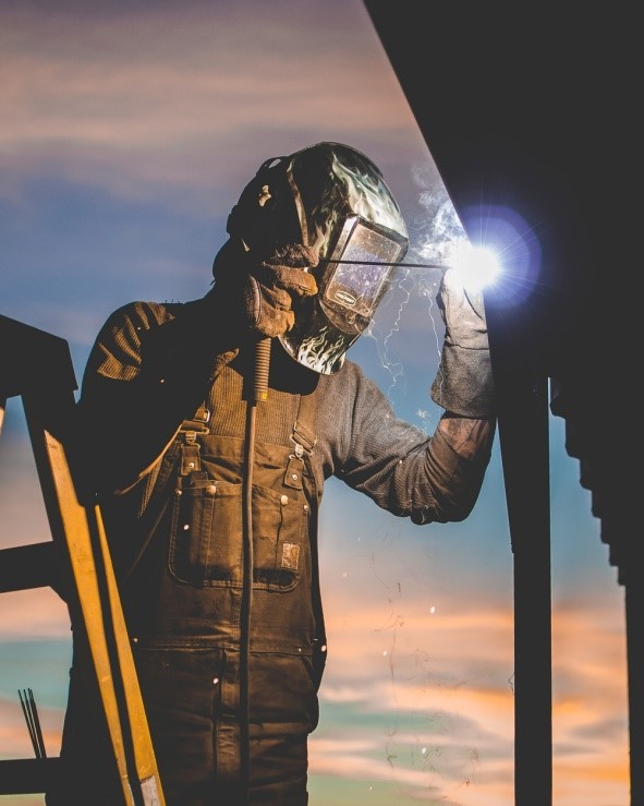 Worker welding wearing Welding helmet and overalls