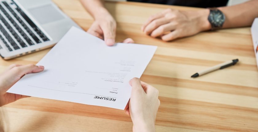 hands passing a resume document