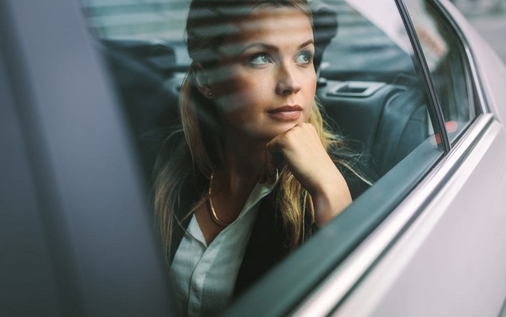 Female business executive travelling by a cab