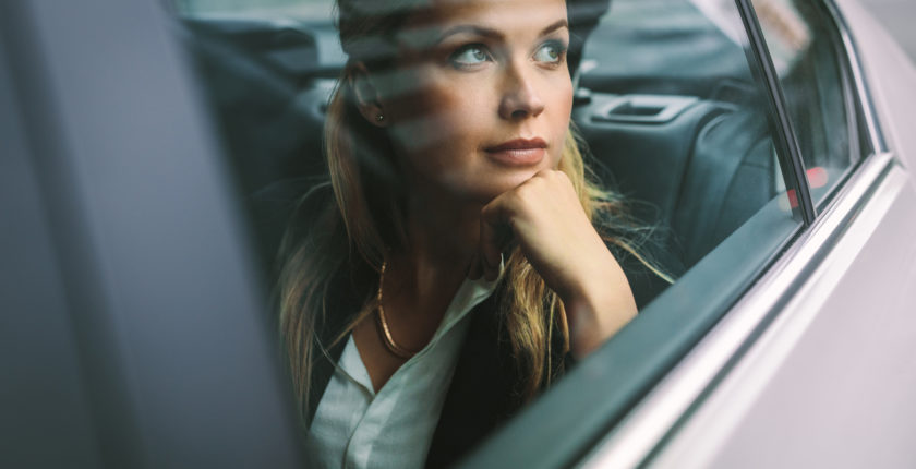 Female business executive travelling by a cab