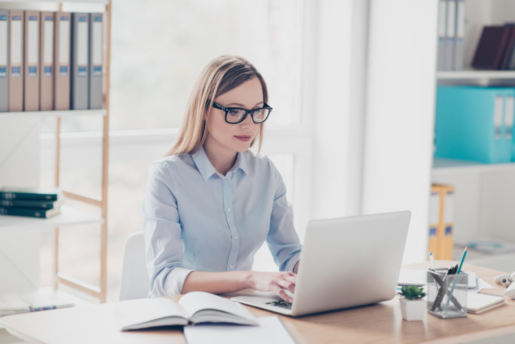 Woman working in an office at her laptop.