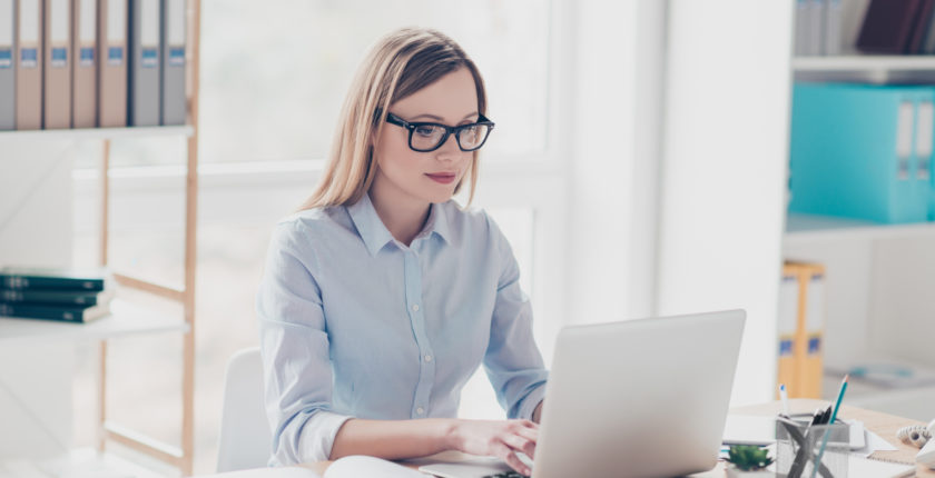 Woman working in an office at her laptop.