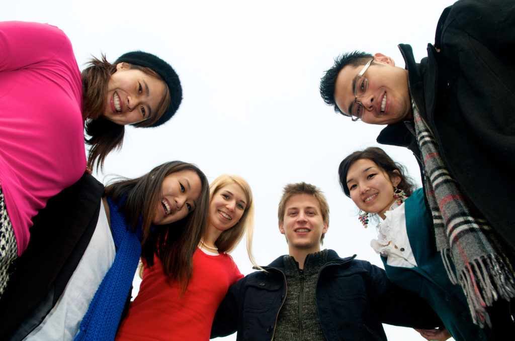 young people gathered in a huddle smiling