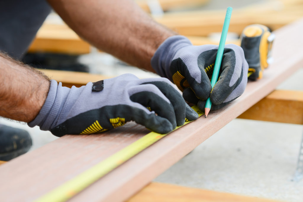 Hands wearing protection gloves using industrial machine for