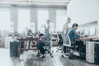 people working in a brightly lit open concept workspace