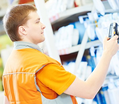 man holding an RF scanner taking stock