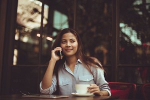 woman on cellphone with coffee cup