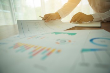 hands of someone shuffling financial report papers