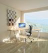 a bright, sunny home office space with a window overlooking forested mountains
