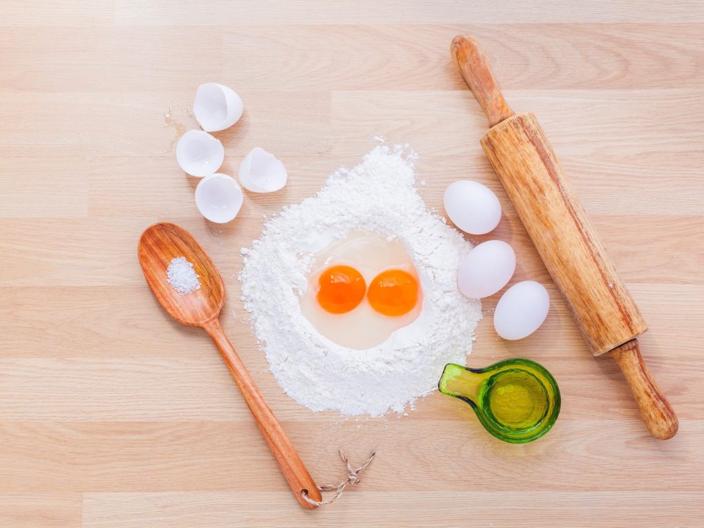 eggs, flower, rolling pin, measuring spoon and cups