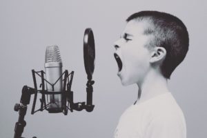 child yelling into microphone