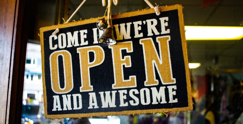 Store window sign that says "Come In We're Open and Awesome"