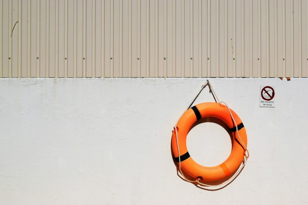 Orange life saver bouy hanging on a wall.