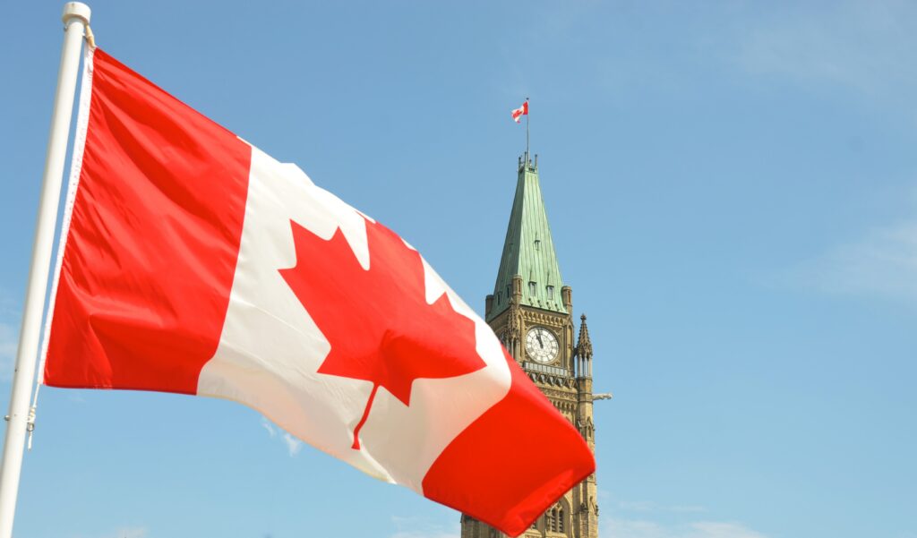 Canadian flag, parliament building in background