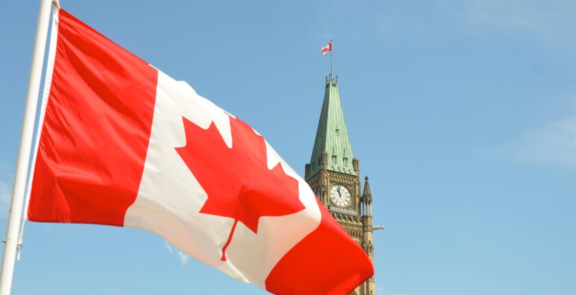 Canadian flag, parliament building in background