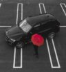 car in parking lot beside person carrying red umbrella