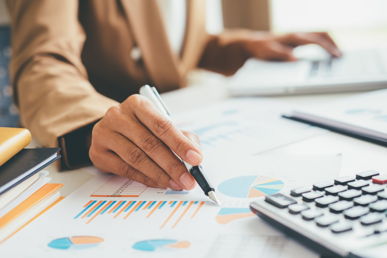 woman's hands working on calculator and holding a pen