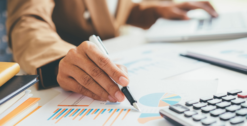 woman's hands working on calculator and holding a pen