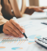 woman's hands working on calculator and holding a pen