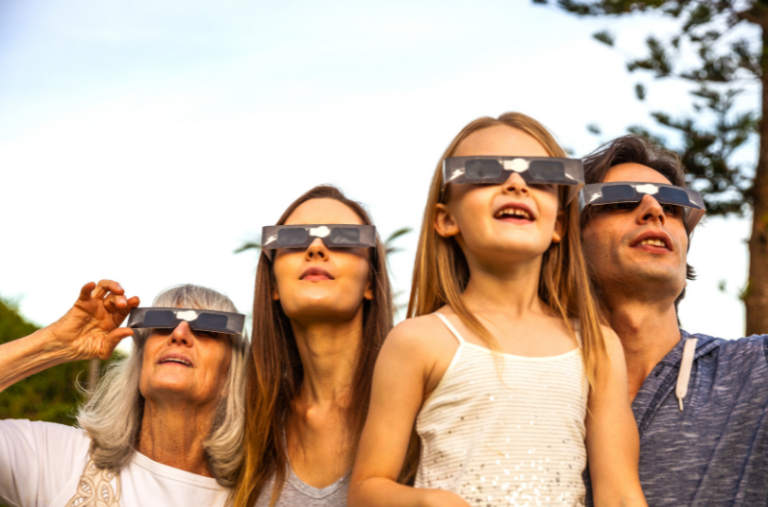 Family wearing solar eclipse glasses