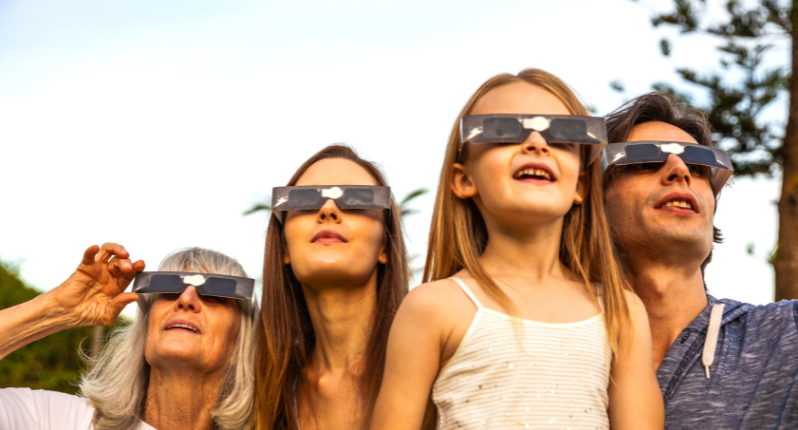 Family wearing solar eclipse glasses