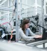 Woman is seated at a worktable in a clean and bright manufacturing facility