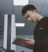 Man holding clipboard checking a list